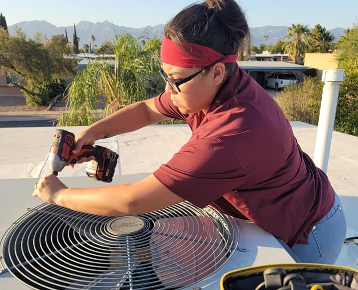 HVAC technician diagnosing air conditioning equipment